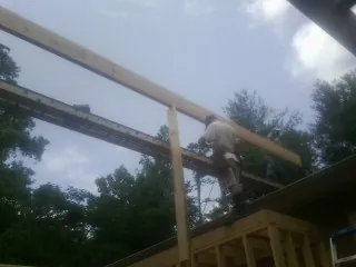 Carpenter setting a ridge beam over a new addition frame — Ice Dam Removal by Roofing Brothers in Boiceville