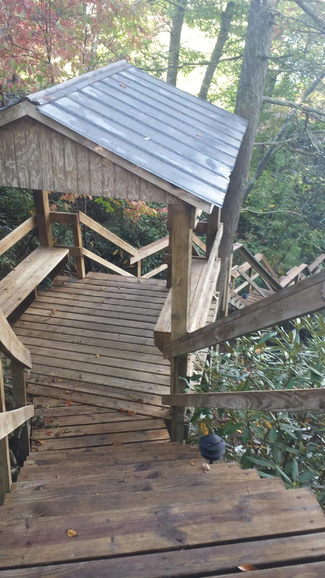 Metal roofed shelter over wooden steps on a wooded walkway — Skylight Repair & Installation work by our crew in Boiceville